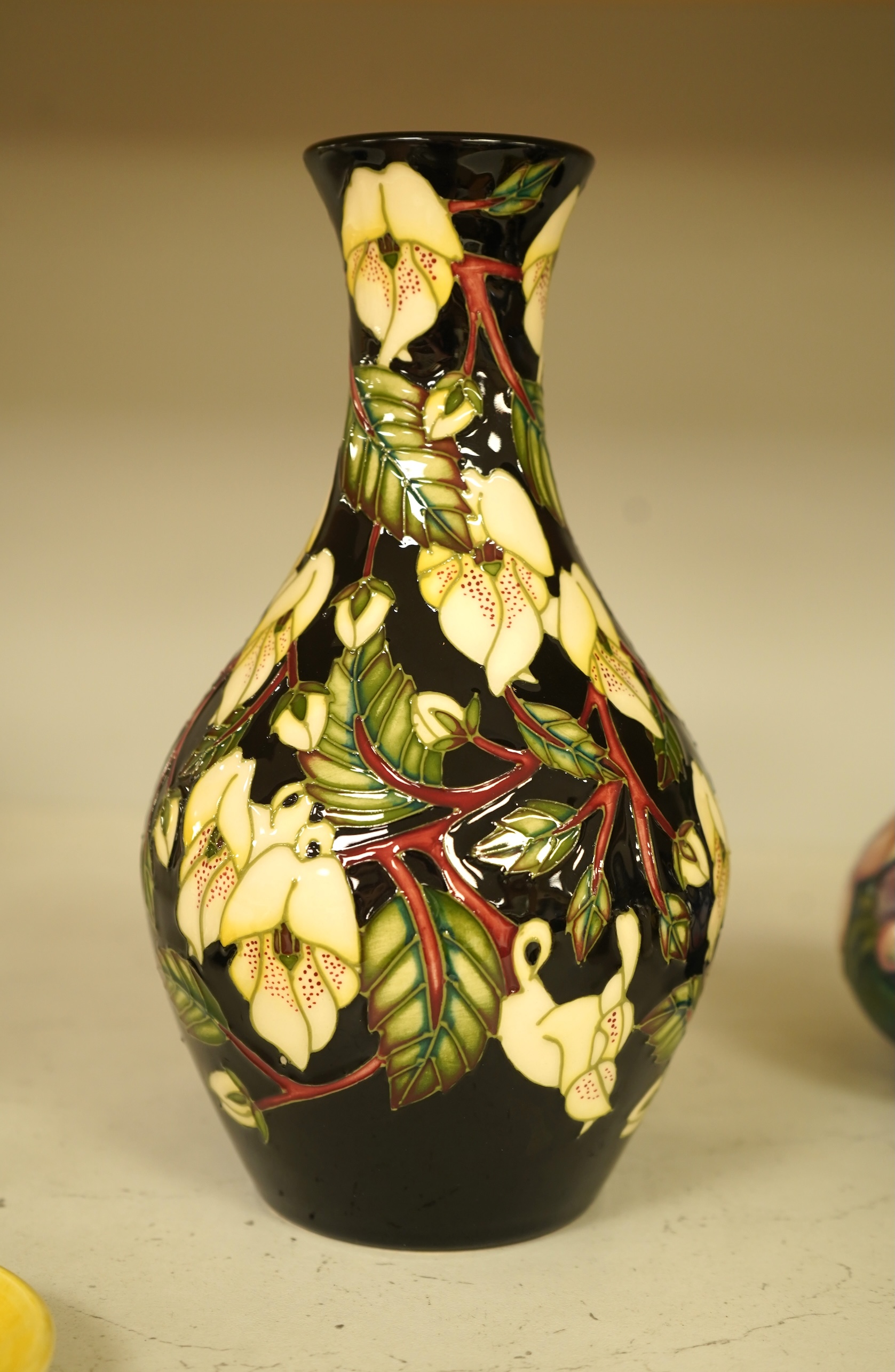A collection of modern Moorcroft to include a mountain gold pattern vase, two pin dishes and a Hibiscus pattern candlestick, largest 20cm high